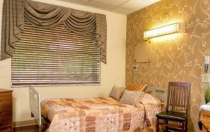 A cozy bedroom with a single bed, decorative curtains, and warm lighting.