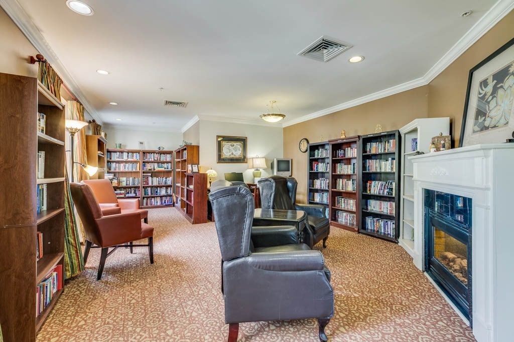 A cozy library room with comfortable armchairs and well-stocked bookshelves.