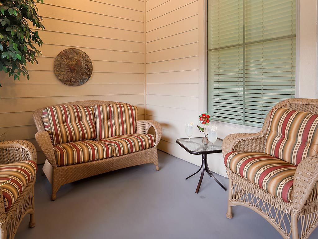 Cozy patio area with striped furniture and a small table featuring a floral arrangement.