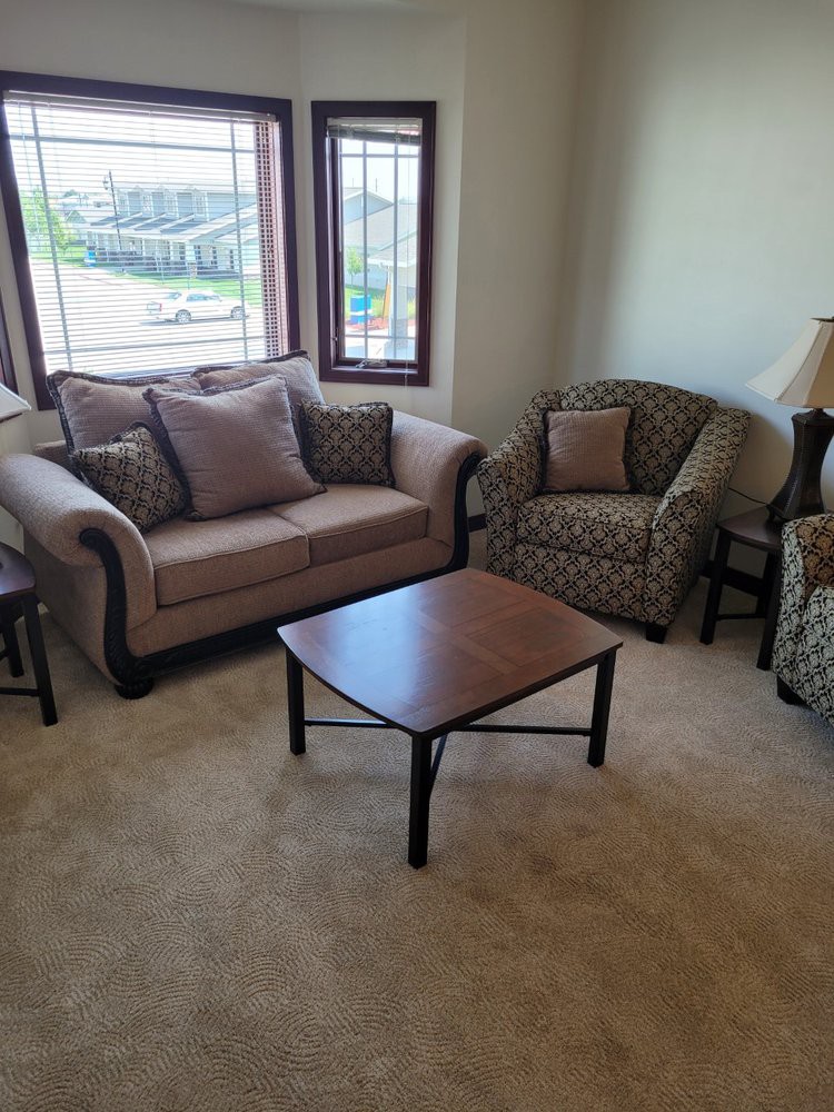 A cozy living room with a sofa, armchairs, and a coffee table.