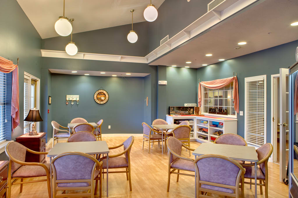 A modern dining area with tables and chairs, featuring decorative lighting.
