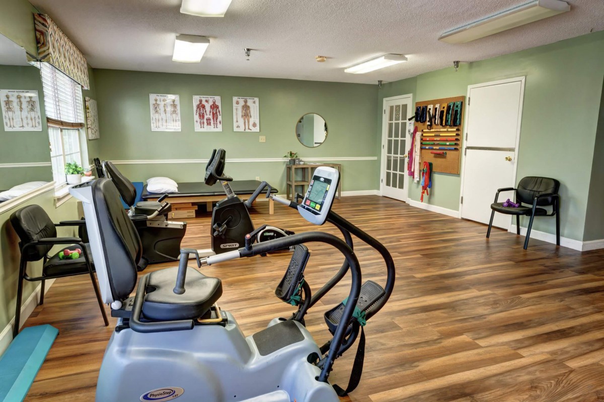 A therapy room equipped with exercise machines and essentials for physical rehabilitation.