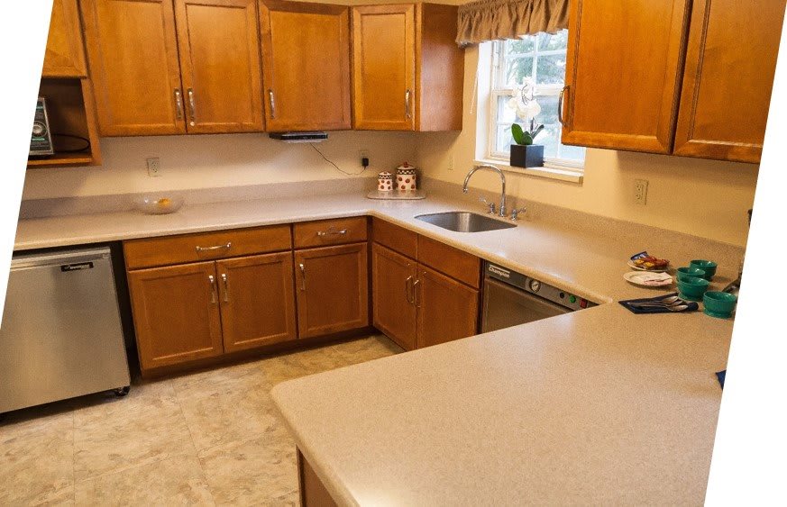 A cozy kitchen featuring wooden cabinets, a dual sink, and a bright window.