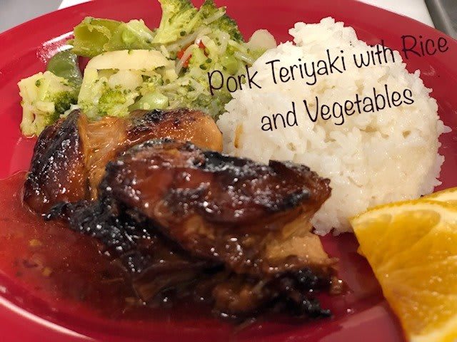 A plate of pork teriyaki served with rice and vegetables.