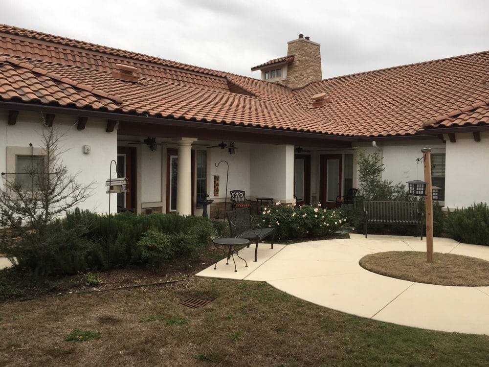 A house with red tile roofing and a courtyard garden.