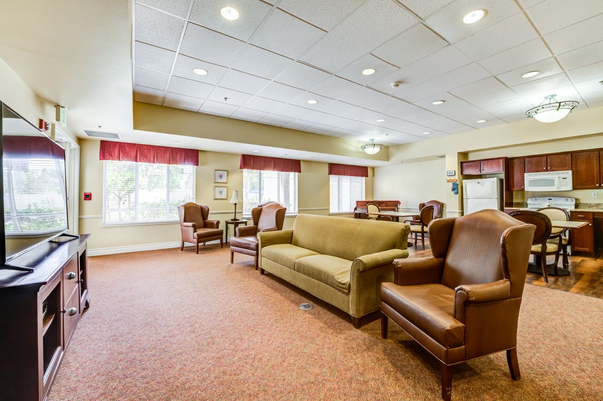 A spacious and well-lit living room with comfortable seating and large windows.