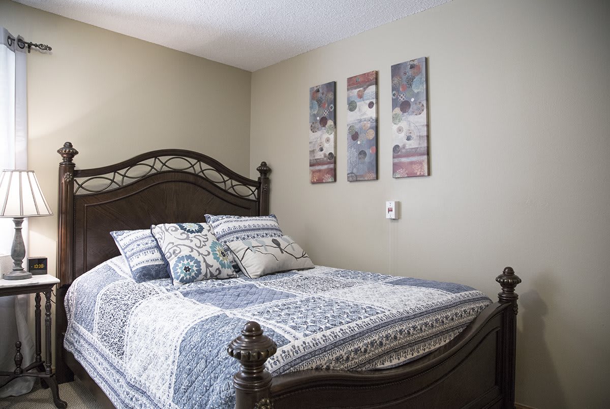 A cozy bedroom with a decorative bed and wall art.