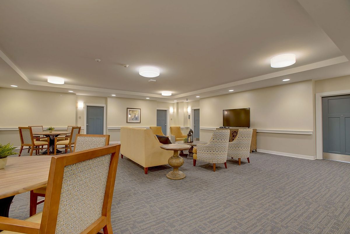 A spacious and well-lit living room with comfortable seating and a television.