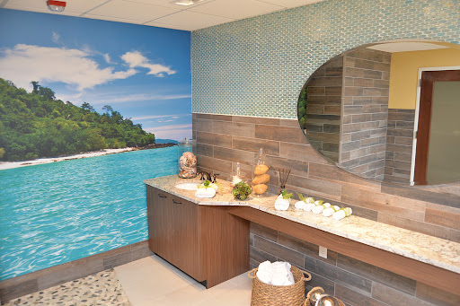 A serene spa bathroom featuring a calming nature mural and elegant wooden features.