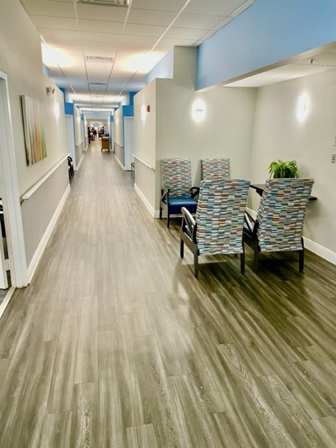 A modern and brightly lit hallway with a set of chairs arranged along one side.