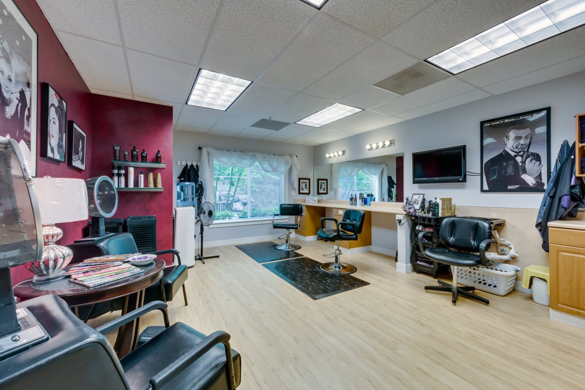 A modern hair salon interior featuring styling stations, mirrors, and a comfortable waiting area.
