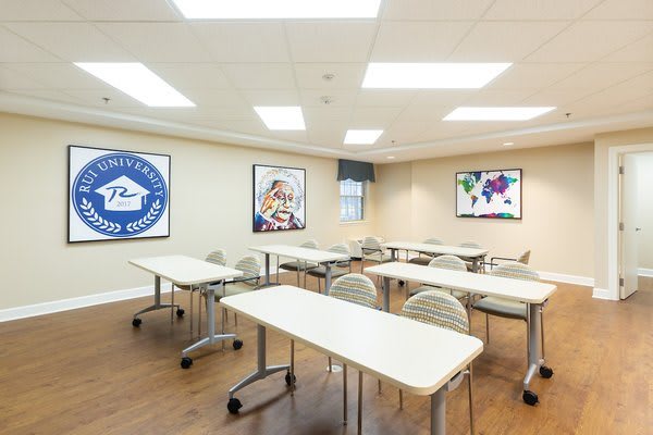 An empty classroom with arranged desks and chairs, ready for a training session or lecture.