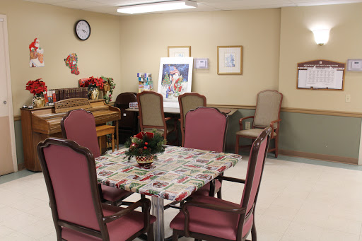 A cozy indoor dining area featuring a table with chairs, decorative elements, and artwork on the walls.