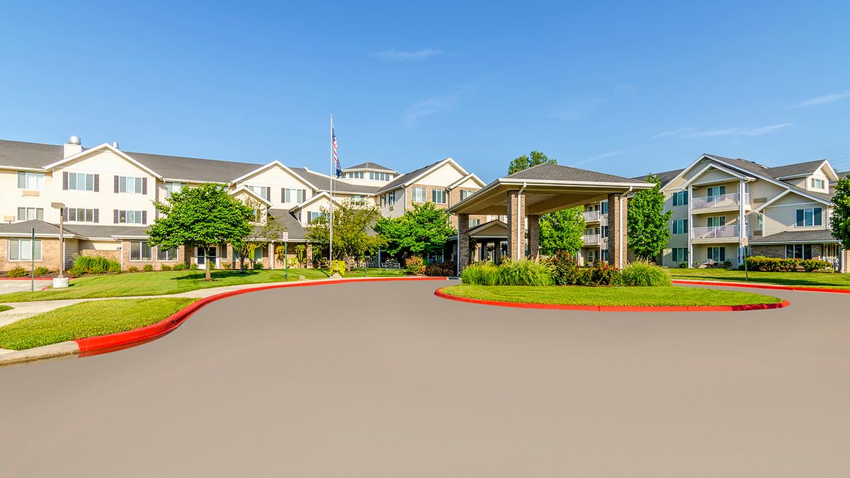 A residential building with landscaped surroundings and a circular driveway.