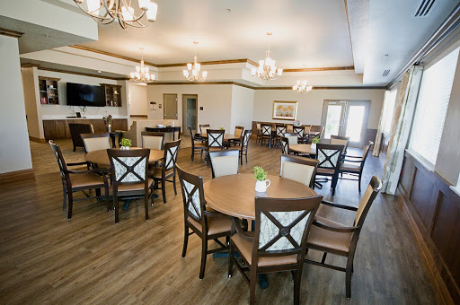 A well-lit dining area featuring elegant furniture and decorative chandeliers.