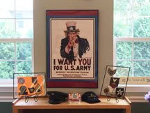 A display featuring a classic 'I Want You for U.S. Army' recruitment poster alongside various military memorabilia.