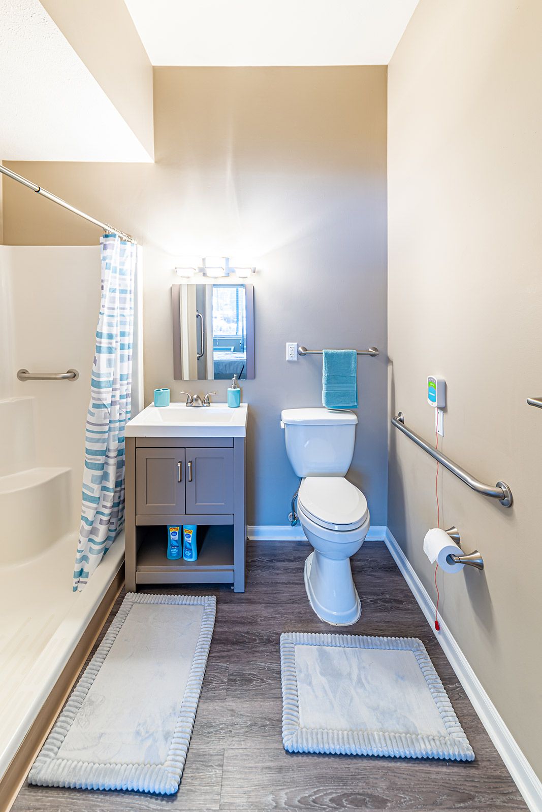 A modern bathroom with a shower, toilet, and sink.