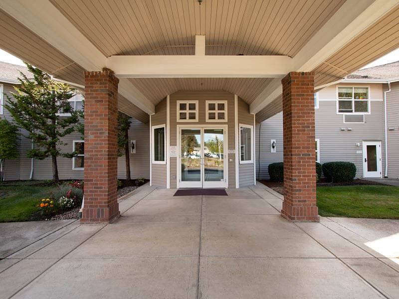 Front entrance of a building with brick columns and a pathway.