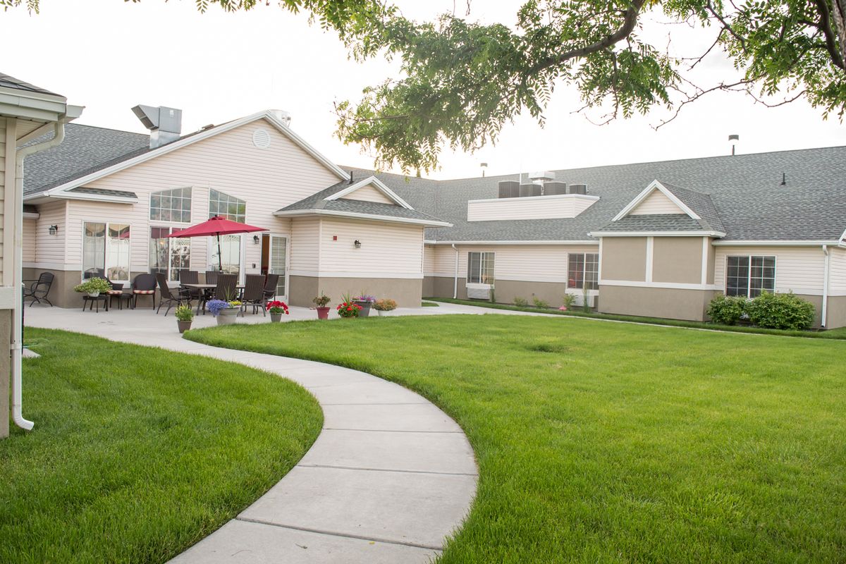 A residential house with a well-maintained lawn and a curved concrete pathway.