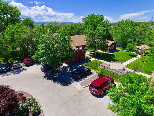 Aerial view of a serene residential area surrounded by lush greenery and a clear blue sky.