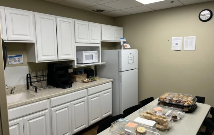 A typical office break room with a kitchen setup, including a microwave and fridge.