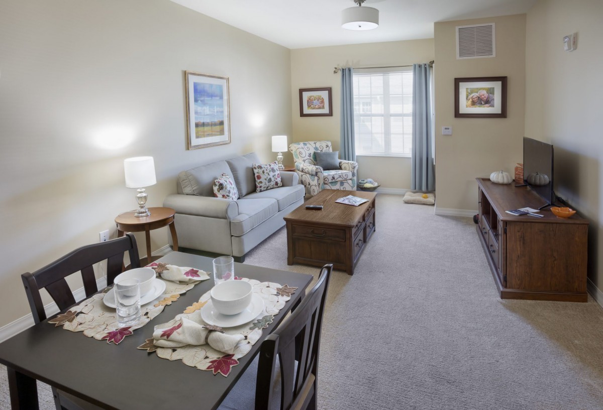 A cozy living room with a sofa and a dining area.