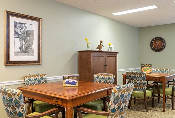 A well-arranged dining room featuring a wooden table and patterned chairs with wall decor.