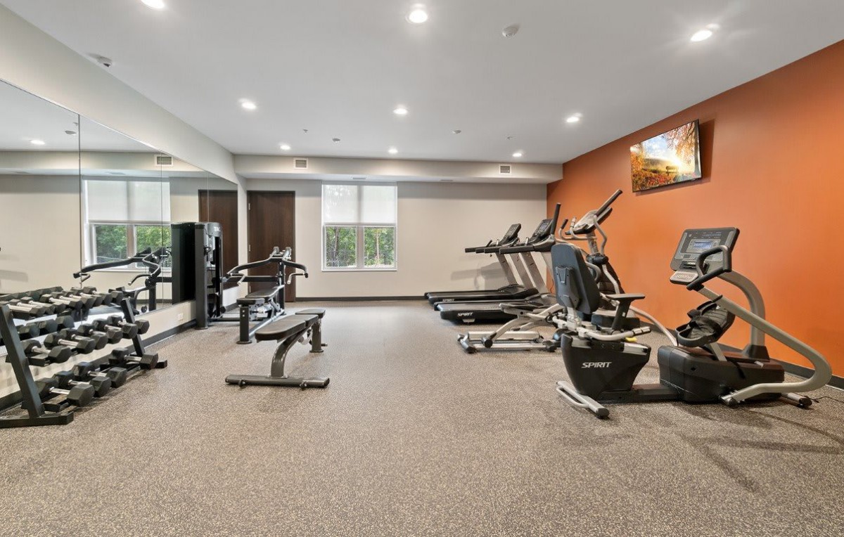 A modern gym with various fitness equipment, including treadmills and exercise machines.
