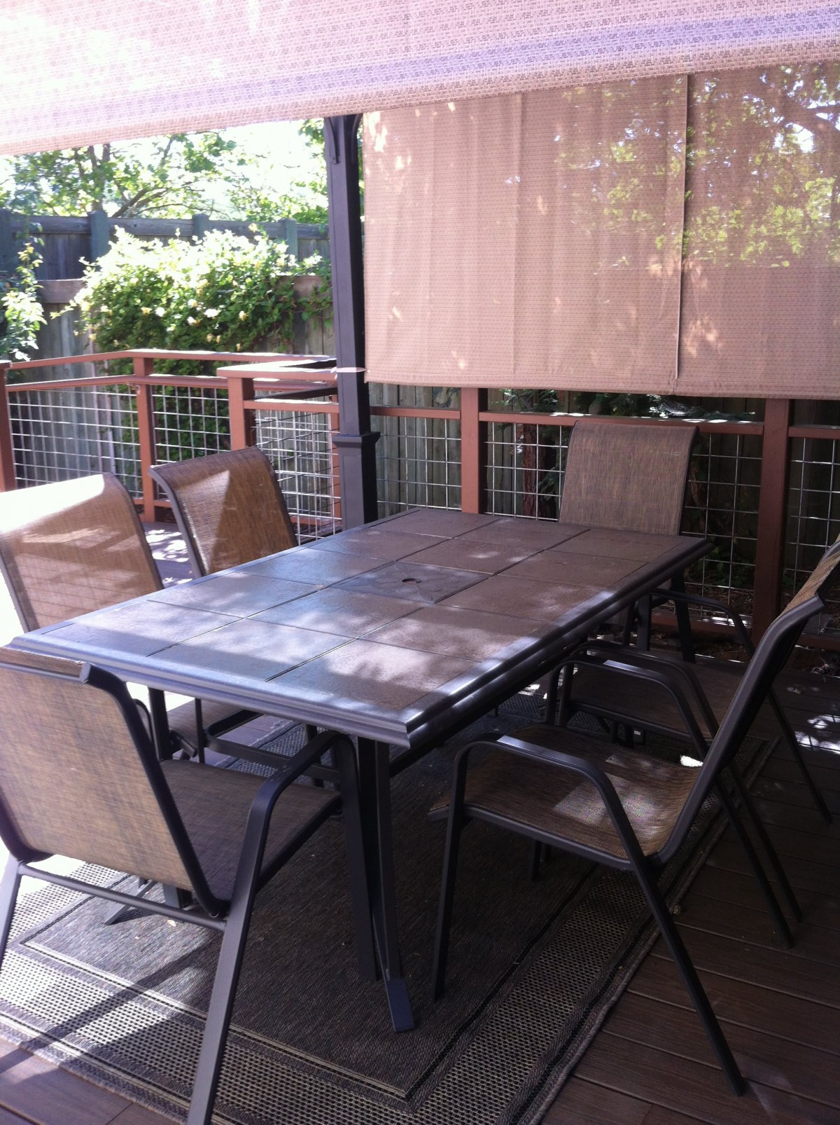 A shaded patio area with a table and chairs.