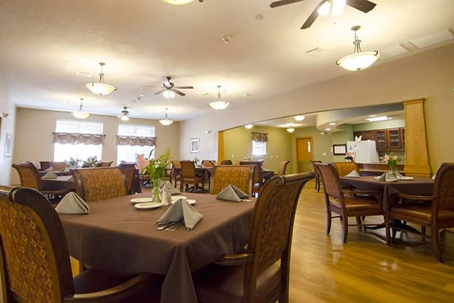 A spacious and elegantly decorated dining area with neatly arranged tables and chairs.