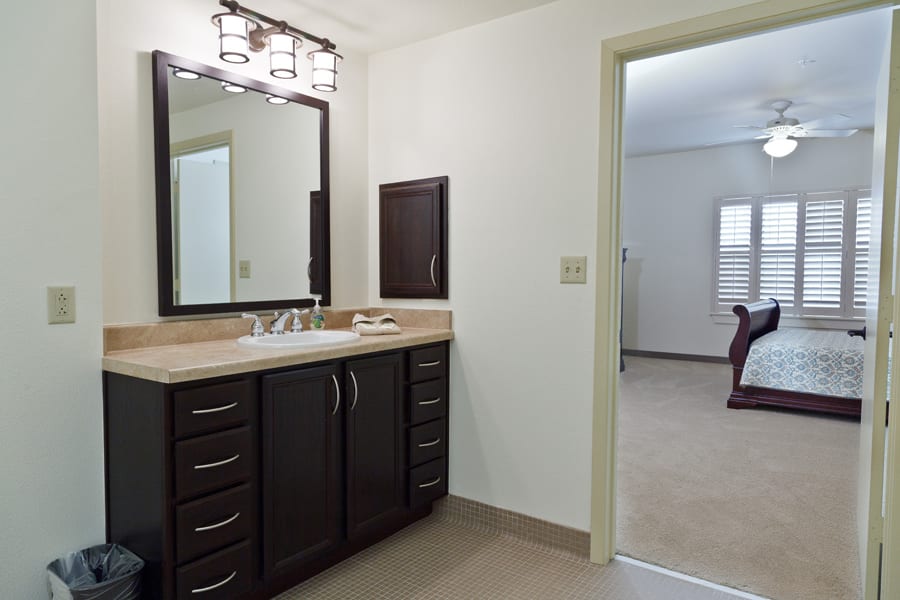 A modern bathroom with a dark wood vanity and large mirror.