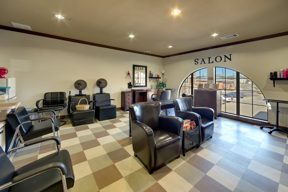 A cozy salon with a checkered floor, featuring chairs for waiting and hair styling, along with a reception desk.