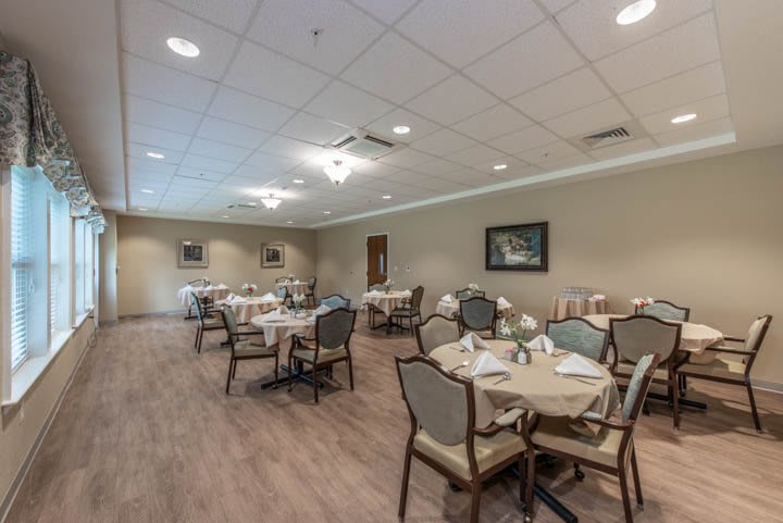 A spacious and elegantly decorated dining room with neatly arranged tables and chairs.