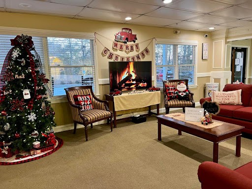 A cozy and festive living room adorned with Christmas decorations, complete with a fire screen and holiday spirit.
