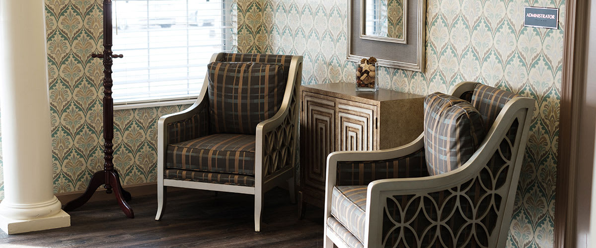 A stylish living room with plaid-patterned chairs and a decorative cabinet.