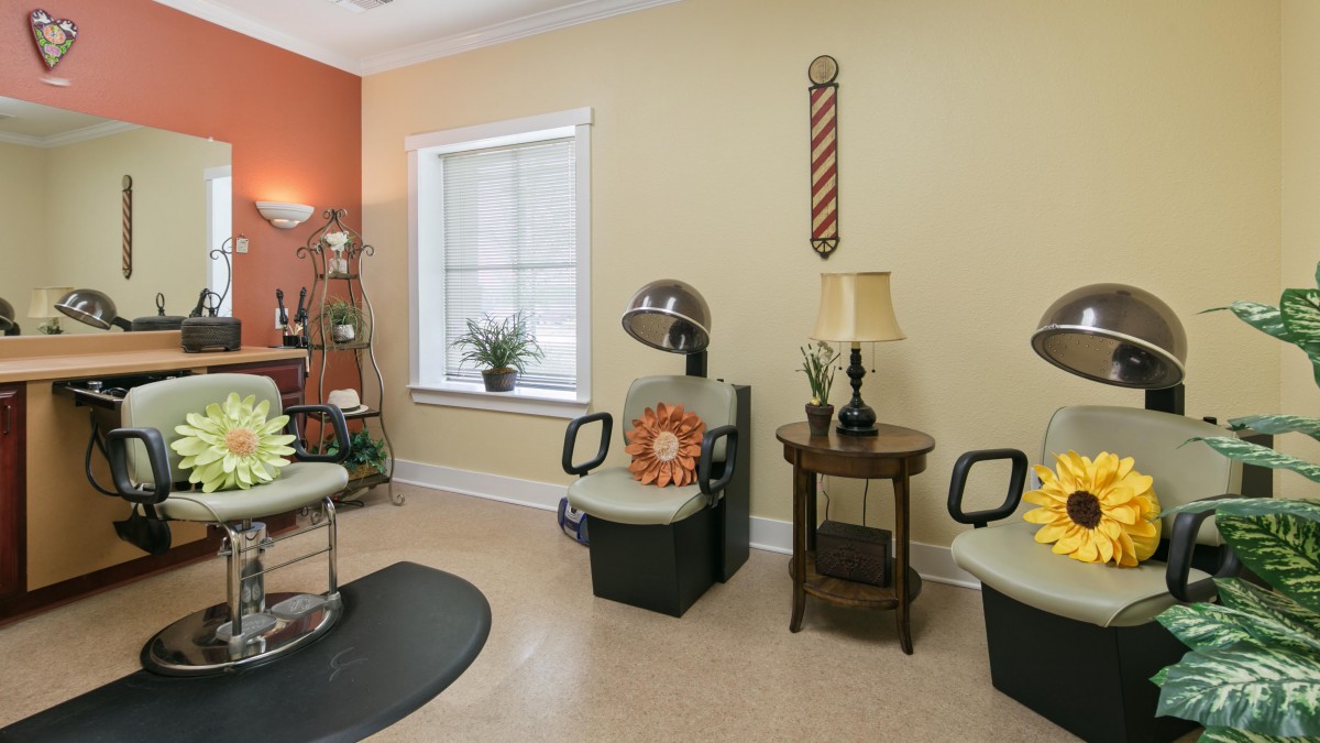 A cozy salon interior featuring barber chairs, a hairdryer station, and decorative elements.