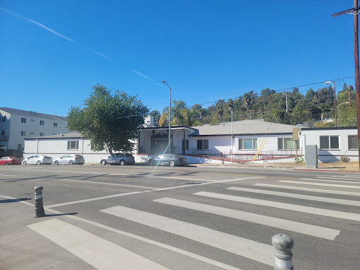 A view of residential houses along a street with a crosswalk under a clear blue sky.