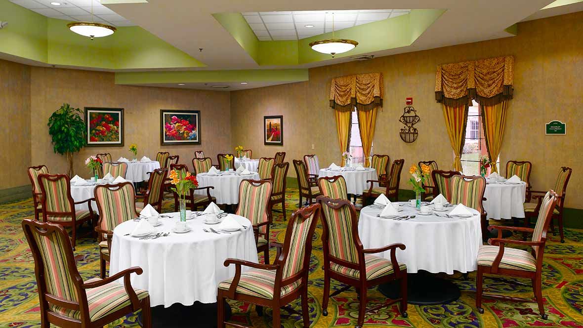 A well-decorated dining area with multiple round tables and chairs, ready for guests.