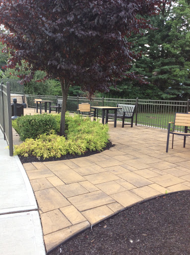 A serene outdoor seating area featuring a well-maintained patio, lush greenery, and comfortable chairs.