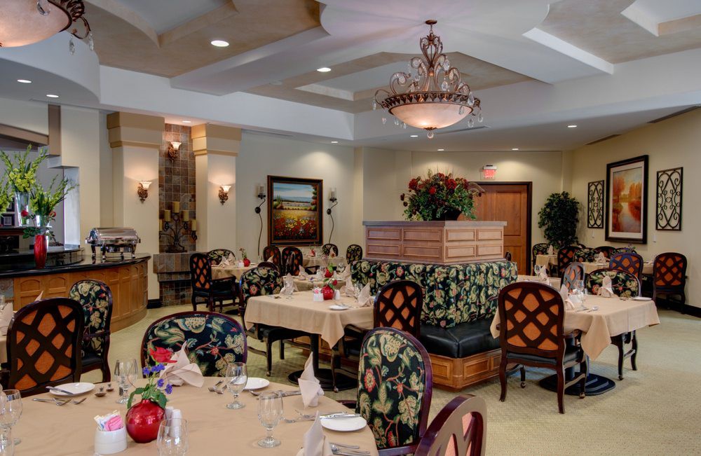 An elegant restaurant interior with a chandelier, well-arranged tables, and stylish decor.