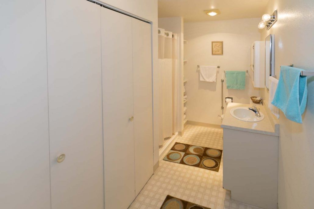 A modern bathroom featuring a sink, mirror, and neatly hung towels.