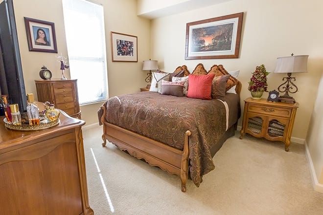 A cozy bedroom with elegant wooden furniture and decorative elements.