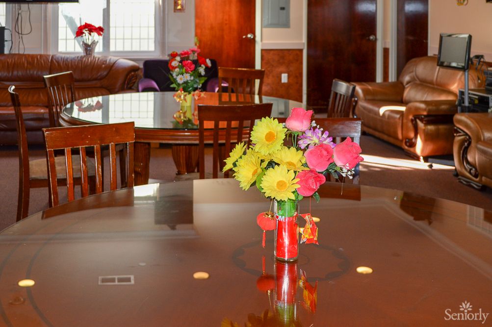 A bright and welcoming lounge area featuring a table with a colorful flower arrangement in a vase.