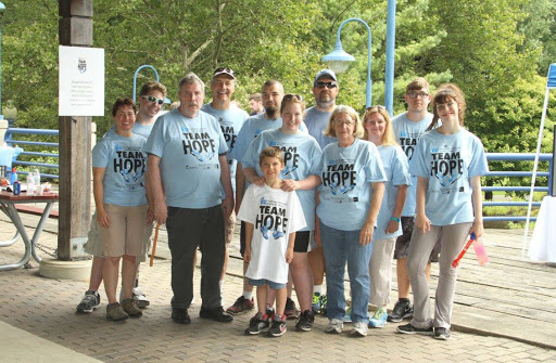 A group of people gathered for an event, all wearing matching blue shirts that promote unity and hope.