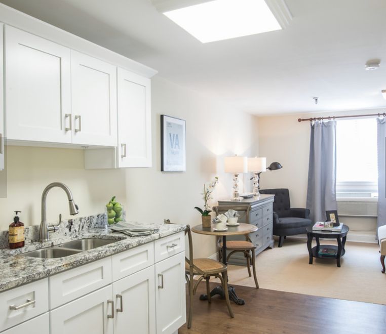 A modern apartment interior featuring a kitchenette and cozy living area.
