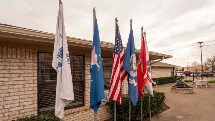 A row of military flags displayed outside a building.