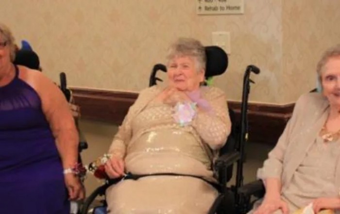 An elderly woman in a wheelchair at a social event.