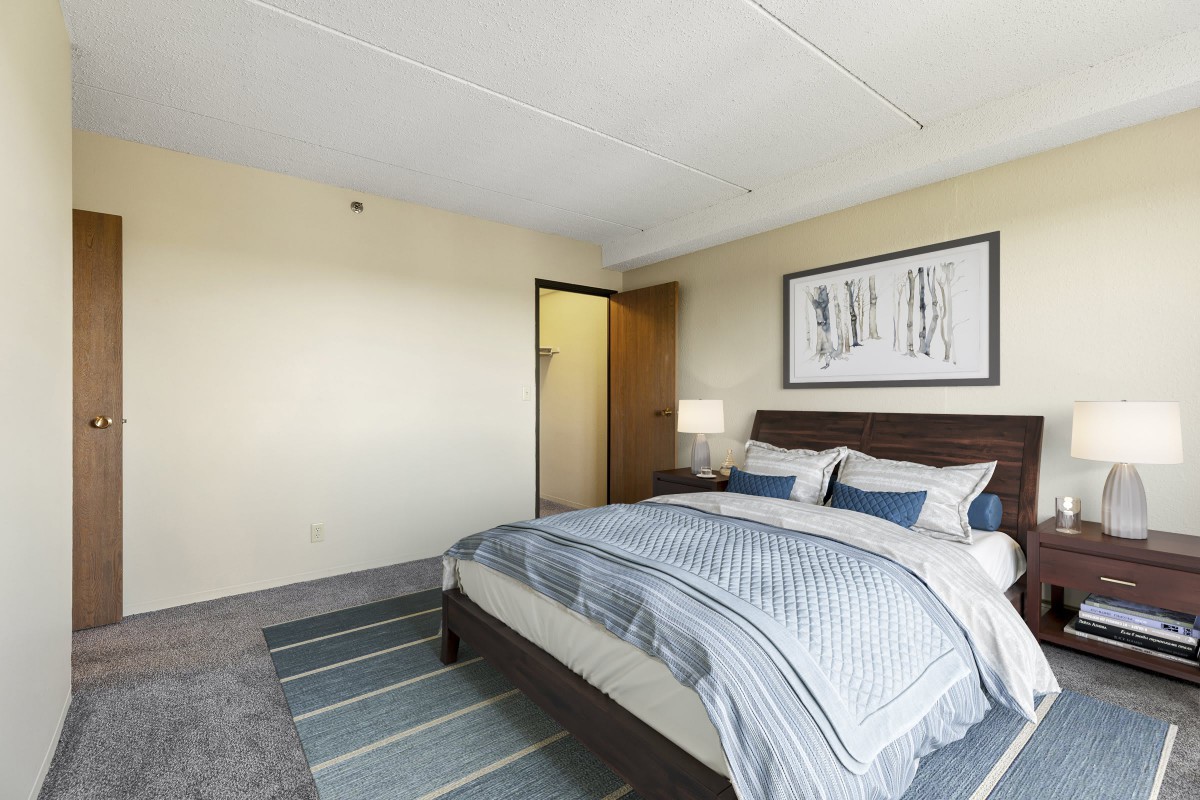 A modern bedroom with a neatly made bed, stylish decor, and soft lighting.