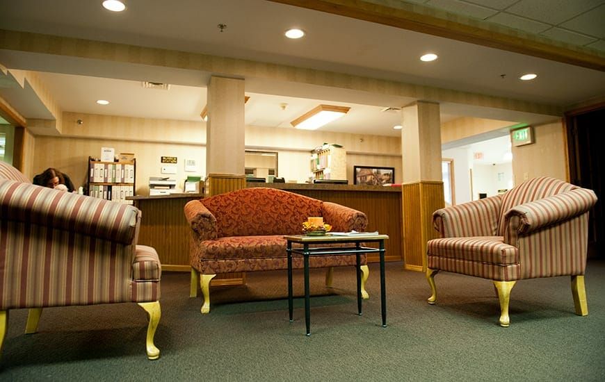 A cozy lobby area featuring classic upholstered furniture and warm lighting.