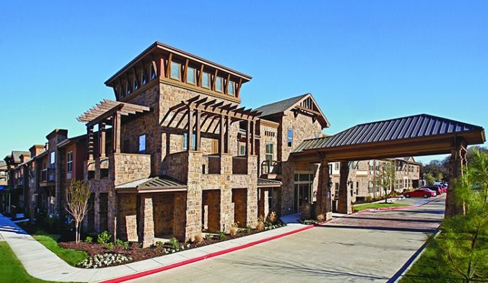 A modern residential building with a brick exterior and unique architectural features.